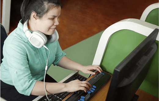 Blind person using a braille display and a computer